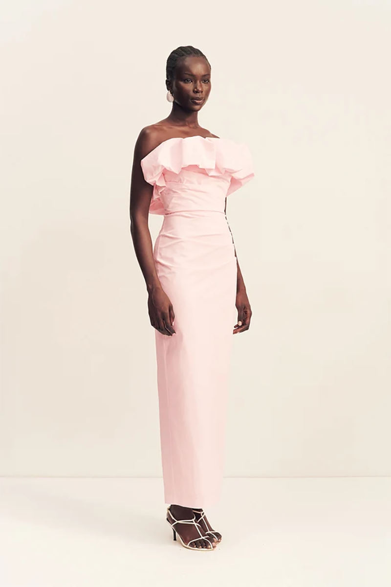 A woman wears a ballerina pink Shona Joy Campbell Strapless Bubble Maxi Dress with a ruffled bodice and thin-strap heels.