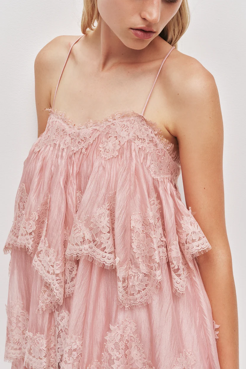 A fawn pink Aje Ophelia Lace Mini Dress featuring spaghetti straps and tiered, lacy ruffle detailing across the bodice.