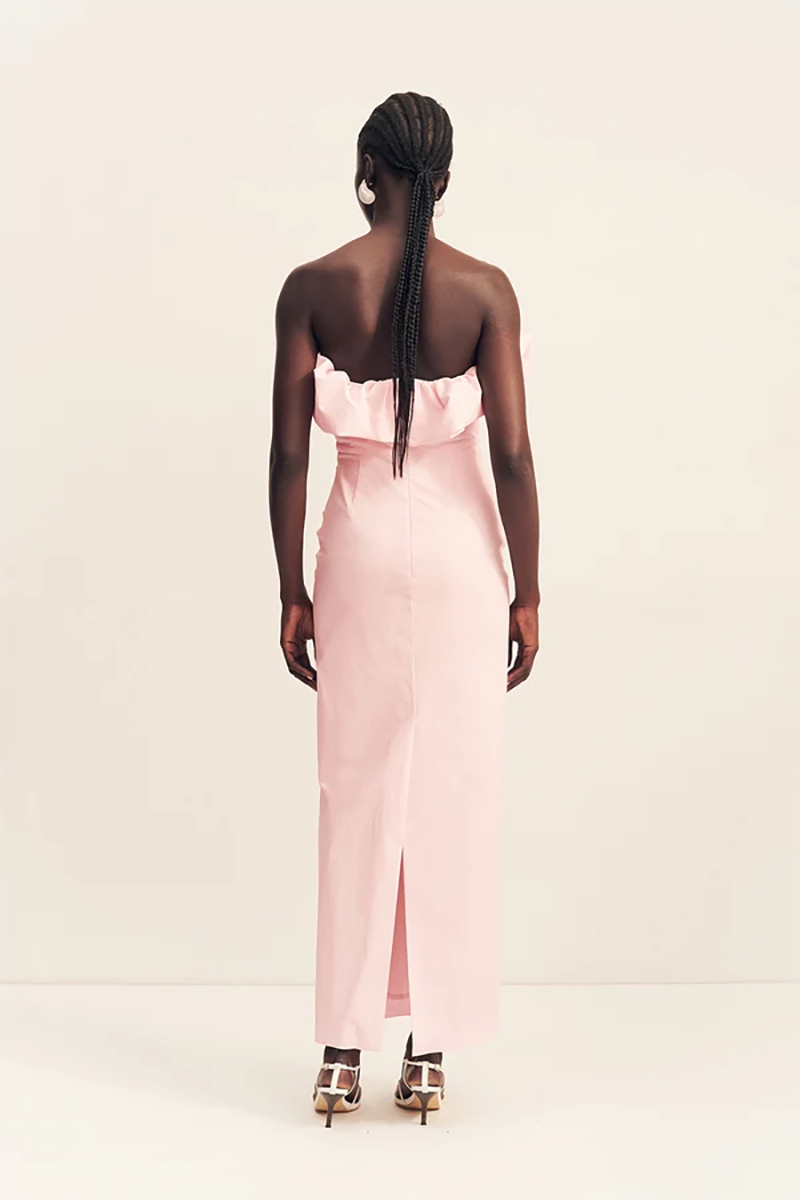 Back view of a person wearing a ballerina pink Shona Joy Campbell Strapless Bubble Maxi Dress with a floor-length hem, a back slit, and strappy heels.
