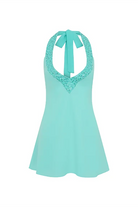 The I Am Delilah Violetta Mini Dress is a turquoise mini dress with a halter neckline featuring crystal embellishments and a tie at the back of the neck.